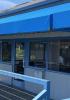 Image of the Modern Sailing office building with blue awning and the Modern Sailing logo on the windows at Clipper Yacht Harbor