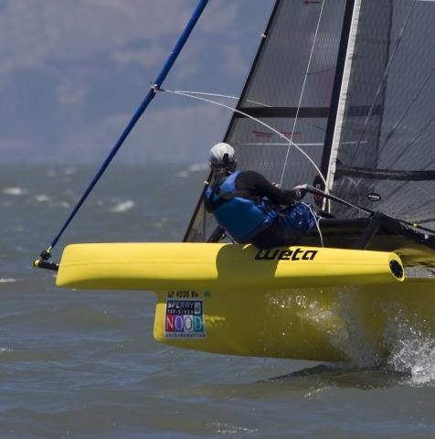 action shot of yellow weta trimaran on the ocean